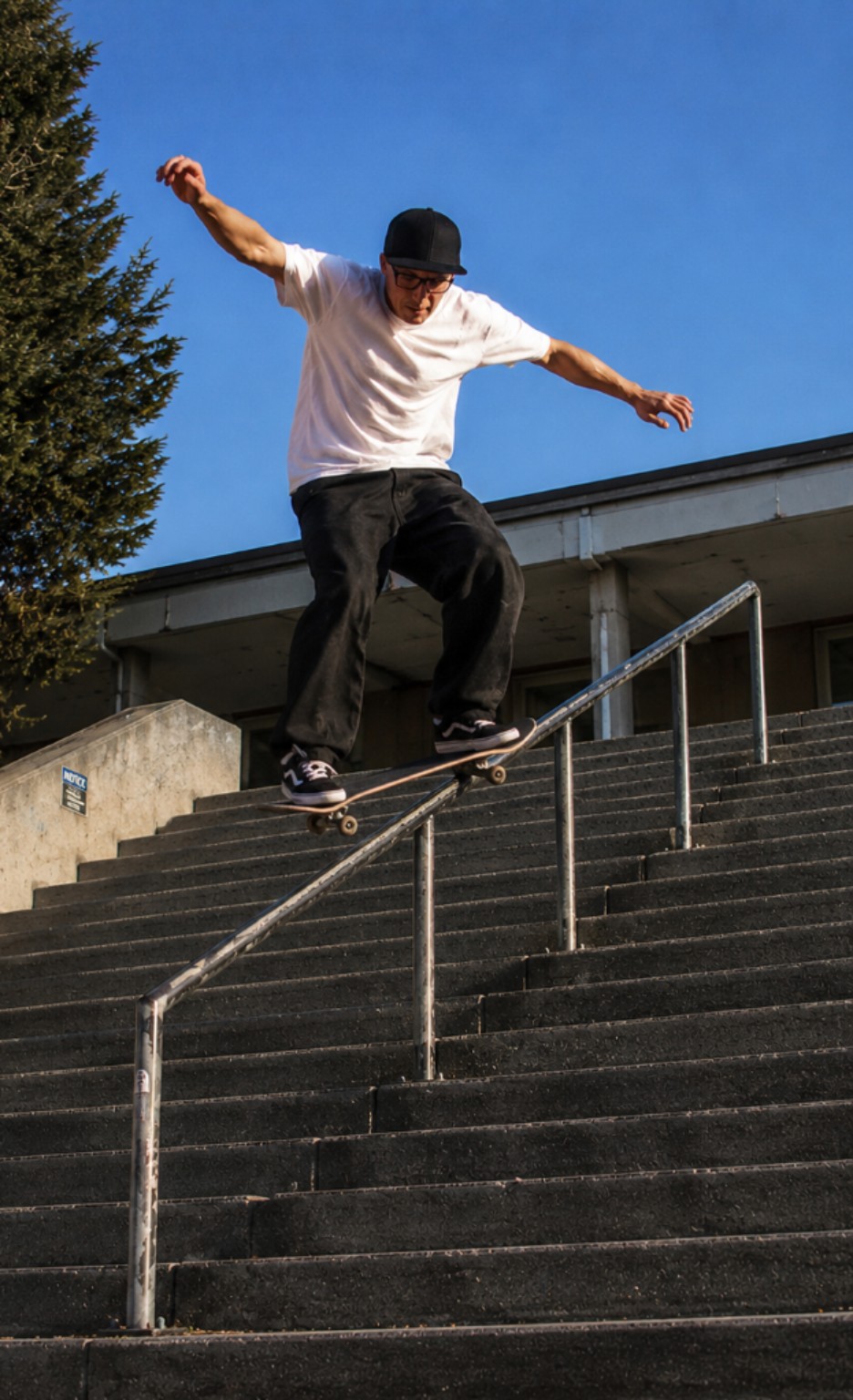 Skateboarder riding a stair rail